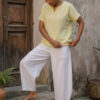 Mujer vistiendo blusa de lino amarillo vainilla y pantalón elegante de lino blanco para clima cálido