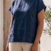 Mujer vistiendo blusa de lino azul marino y pantalon de lino avena estilo slow living