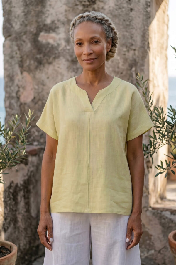 Mujer vistiendo blusa de lino amarillo vainilla y pantalón elegante de lino blanco para clima cálido