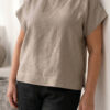 Mujer vistiendo blusa de lino taupe y pantalon elegante de lino negro estilo slow fashion