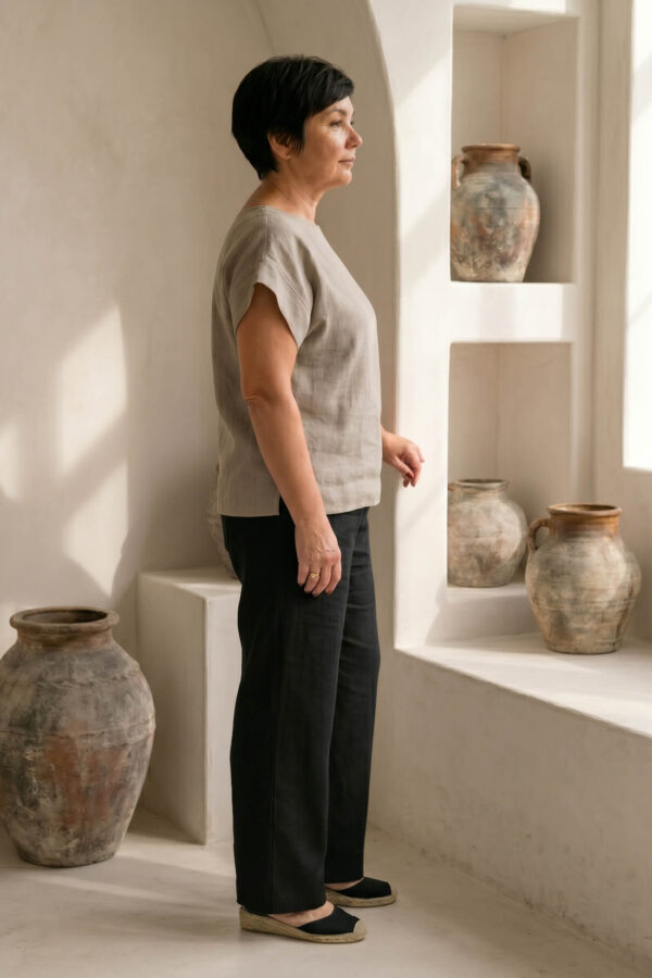 Mujer vistiendo blusa de lino taupe y pantalon elegante de lino negro estilo slow fashion