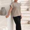 Mujer vistiendo blusa de lino taupe y pantalon elegante de lino negro estilo slow fashion