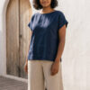 Mujer vistiendo blusa de lino azul marino y pantalon de lino avena estilo slow living