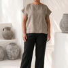 Mujer vistiendo blusa de lino taupe y pantalon elegante de lino negro estilo slow fashion