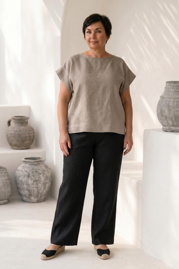 Mujer vistiendo blusa de lino taupe y pantalon elegante de lino negro estilo slow fashion