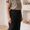 Mujer vistiendo blusa de lino taupe y pantalon elegante de lino negro estilo slow fashion