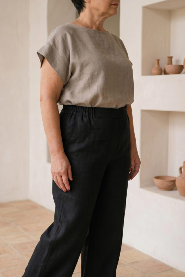 Mujer vistiendo blusa de lino taupe y pantalon elegante de lino negro estilo slow fashion