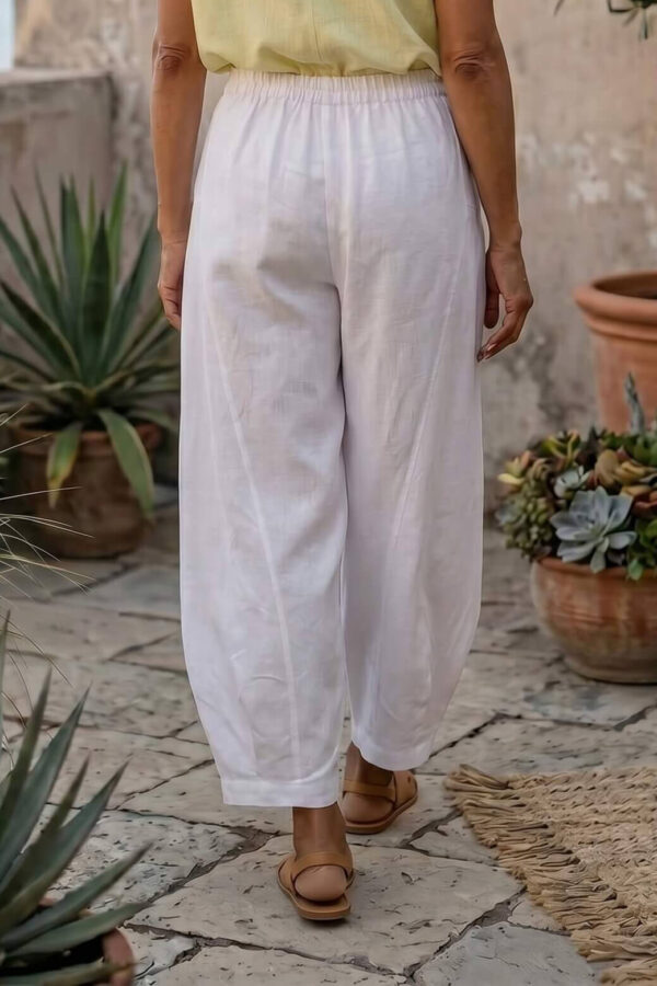 Mujer vistiendo blusa de lino amarillo vainilla y pantalón elegante de lino blanco para clima cálido