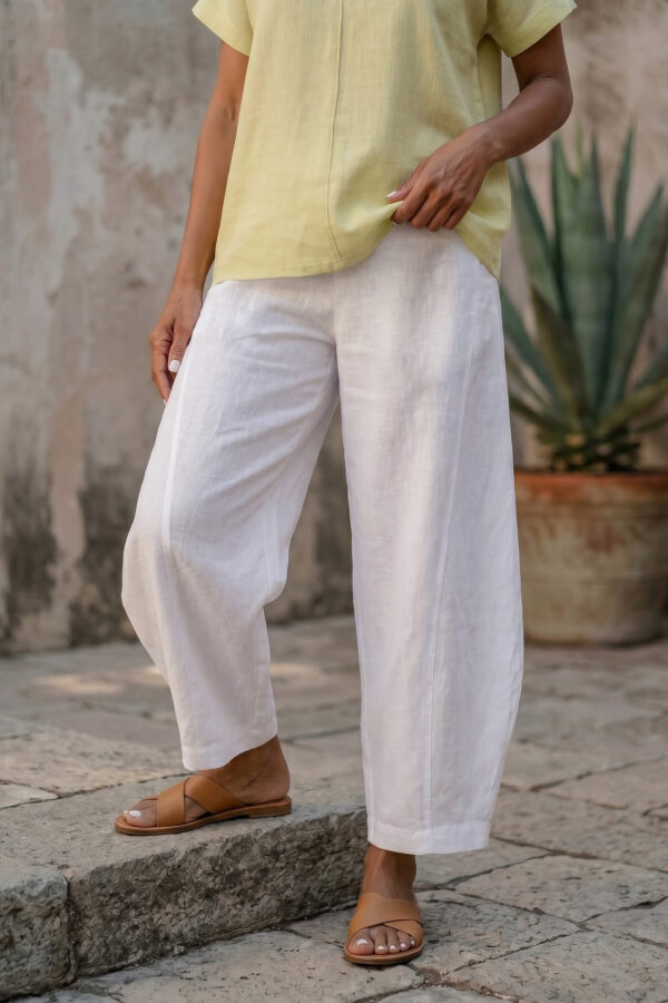 Mujer vistiendo blusa de lino amarillo vainilla y pantalón elegante de lino blanco para clima cálido