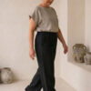 Mujer vistiendo blusa de lino taupe y pantalon elegante de lino negro estilo slow fashion