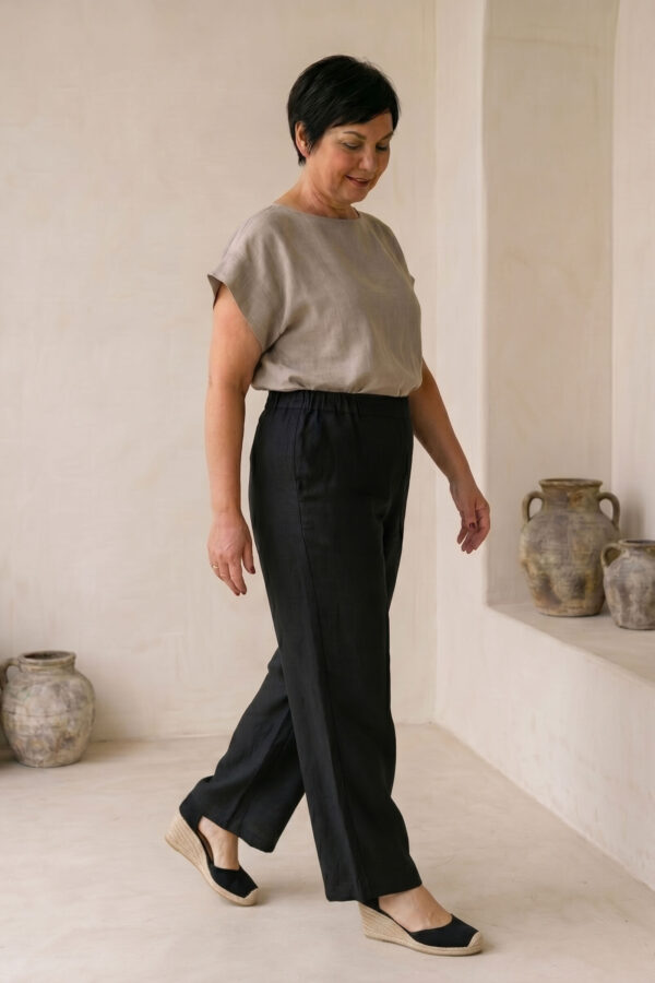 Mujer vistiendo blusa de lino taupe y pantalon elegante de lino negro estilo slow fashion