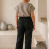 Mujer vistiendo blusa de lino taupe y pantalon elegante de lino negro estilo slow fashion