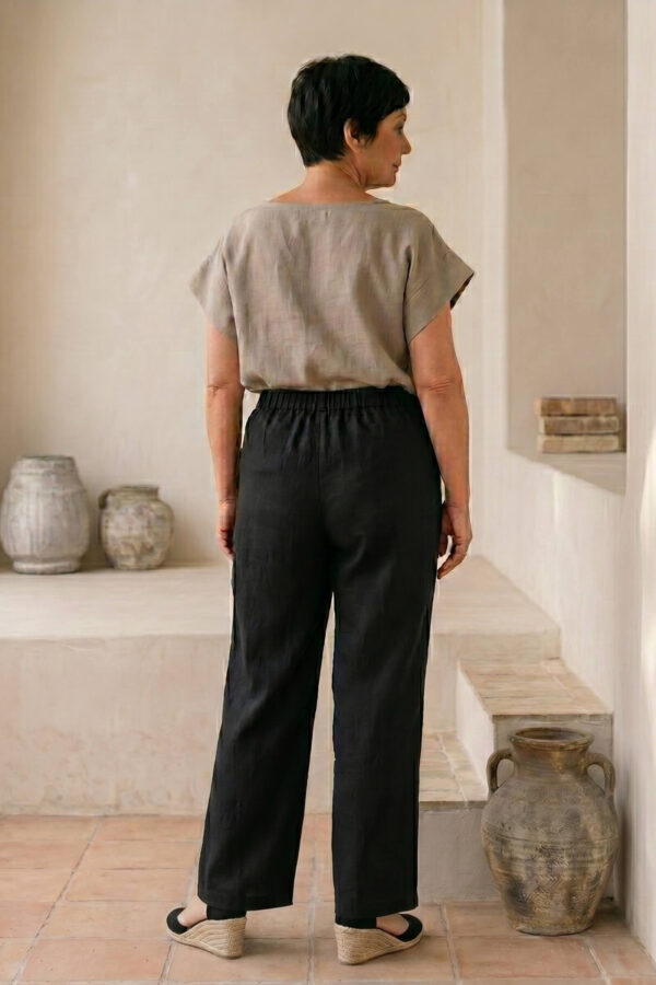 Mujer vistiendo blusa de lino taupe y pantalon elegante de lino negro estilo slow fashion
