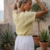 Mujer vistiendo blusa de lino amarillo vainilla y pantalón elegante de lino blanco para clima cálido