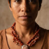 Mujer con collar artesanal rojo de estilo natural en jaspe y ágata