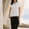 Mujer vistiendo outfit elegante con blusa blanca de lino y pantalon de lino negro