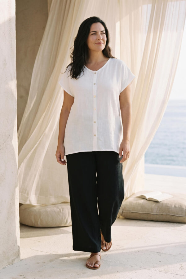 Mujer vistiendo outfit elegante con blusa blanca de lino y pantalon de lino negro