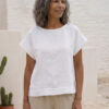Mujer vistiendo blusa blanca de lino y pantalon de lino avena para clima calido