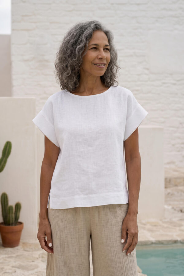 Mujer vistiendo blusa blanca de lino y pantalon de lino avena para clima calido