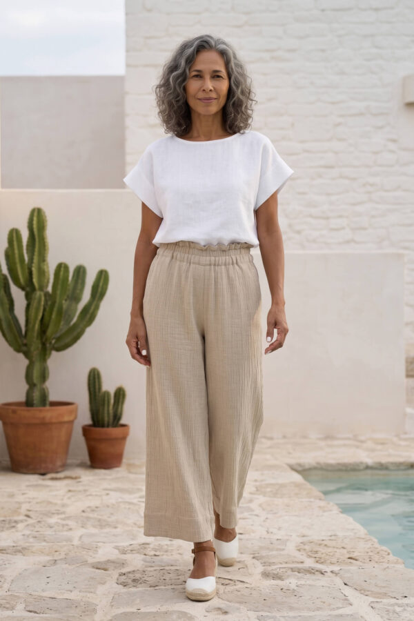 Mujer vistiendo blusa blanca de lino y pantalon de lino avena para clima calido