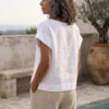 Mujer vistiendo blusa blanca de lino y pantalon de lino avena para clima calido