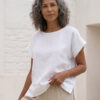Mujer vistiendo blusa blanca de lino y pantalon de lino avena para clima calido