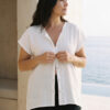 Mujer vistiendo outfit elegante con blusa blanca de lino y pantalon de lino negro