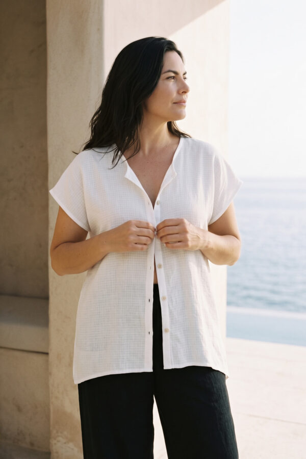 Mujer vistiendo outfit elegante con blusa blanca de lino y pantalon de lino negro