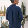 Mujer vistiendo blusa de lino azul marino y pantalon de lino blanco para clima calido