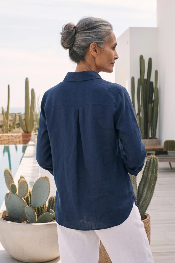 Mujer vistiendo blusa de lino azul marino y pantalon de lino blanco para clima calido