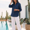 Mujer vistiendo blusa de lino azul marino y pantalon de lino blanco para clima calido