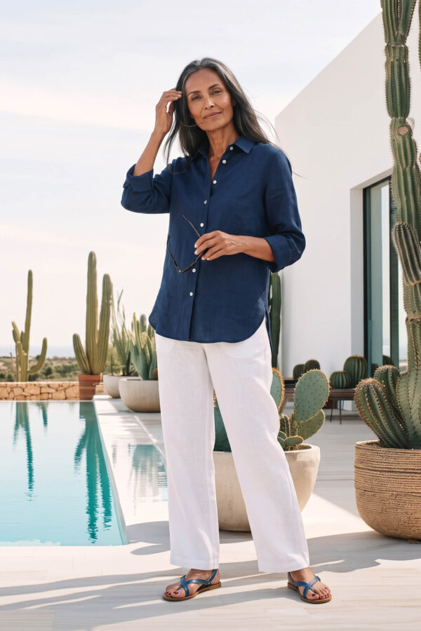 Mujer vistiendo blusa de lino azul marino y pantalon de lino blanco para clima calido