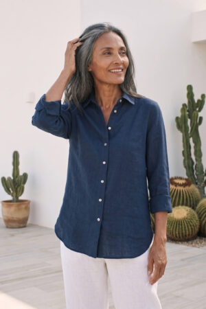 Mujer vistiendo blusa de lino azul marino y pantalon de lino blanco para clima calido