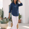 Mujer vistiendo blusa de lino azul marino y pantalon de lino blanco para clima calido