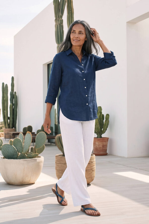 Mujer vistiendo blusa de lino azul marino y pantalon de lino blanco para clima calido