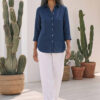 Mujer vistiendo blusa de lino azul marino y pantalon de lino blanco para clima calido