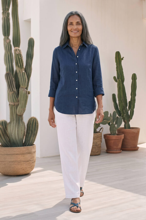 Mujer vistiendo blusa de lino azul marino y pantalon de lino blanco para clima calido