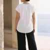 Mujer vistiendo outfit elegante con blusa blanca de lino y pantalon de lino negro