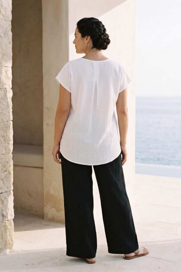 Mujer vistiendo outfit elegante con blusa blanca de lino y pantalon de lino negro