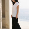 Mujer vistiendo outfit elegante con blusa blanca de lino y pantalon de lino negro