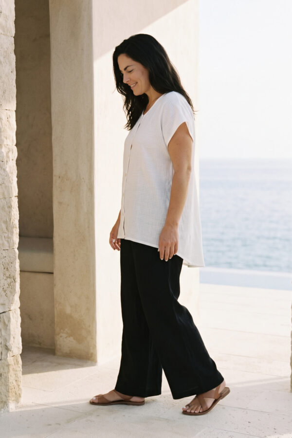 Mujer vistiendo outfit elegante con blusa blanca de lino y pantalon de lino negro