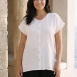 Mujer vistiendo outfit elegante con blusa blanca de lino y pantalon de lino negro