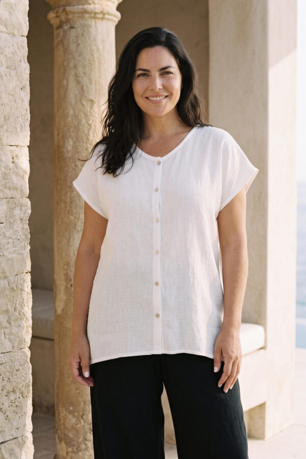 Mujer vistiendo outfit elegante con blusa blanca de lino y pantalon de lino negro