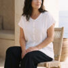 Mujer vistiendo outfit elegante con blusa blanca de lino y pantalon de lino negro