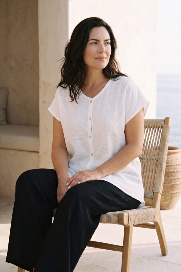 Mujer vistiendo outfit elegante con blusa blanca de lino y pantalon de lino negro