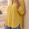 Mujer vistiendo blusa con botones de lino amarilla y pantalon estilo jeans de lino y algodón