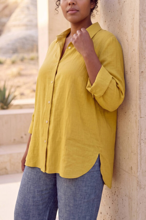 Mujer vistiendo blusa con botones de lino amarilla y pantalon estilo jeans de lino y algodón