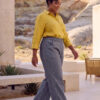 Mujer vistiendo blusa con botones de lino amarilla y pantalon estilo jeans de lino y algodón