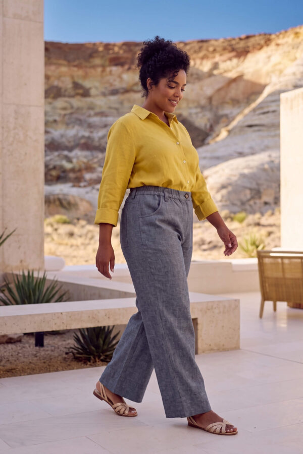Mujer vistiendo blusa con botones de lino amarilla y pantalon estilo jeans de lino y algodón
