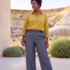 Mujer vistiendo blusa con botones de lino amarilla y pantalon estilo jeans de lino y algodón